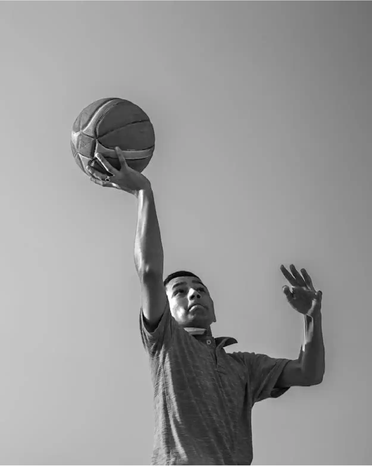 Basketball player reaching up with the ball